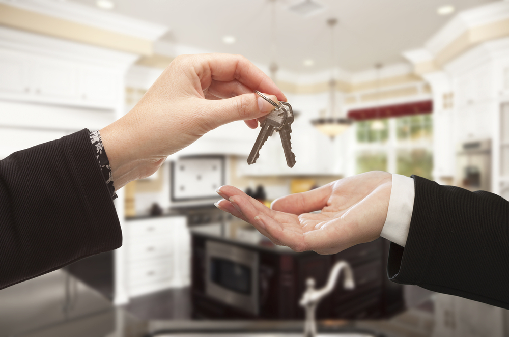 Woman handing keys to buyer